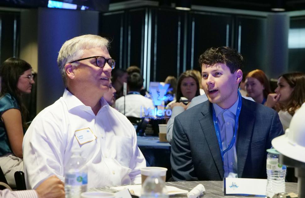 Intern seated and conversating with Kooilspetroleum's President and CEO, Lane Riggs.